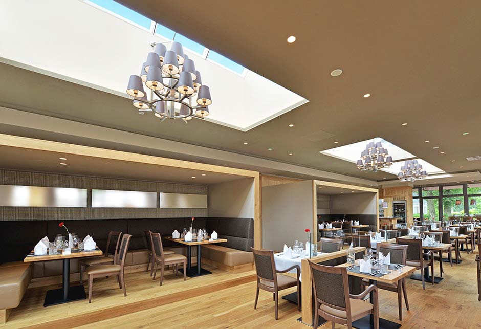 Widok wnętrza restauracji z modułami pasma świetlnego dwuspadowego 25–40˚, kompleks Jammertal Hotel Resort, Niemcy